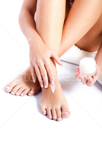 Body care. Woman applying cream on legs Stock photo © nenetus