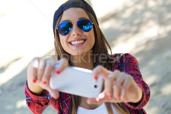 Portrait of beautiful girl taking a selfie with mobile phone in  Stock photo © nenetus