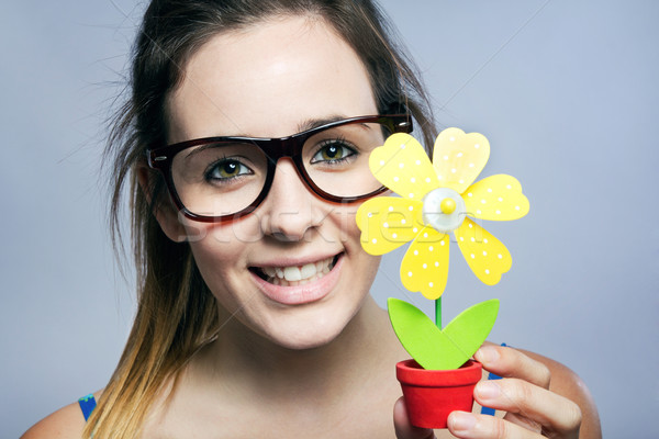 Beautiful young woman showing one artificial daisy Stock photo © nenetus