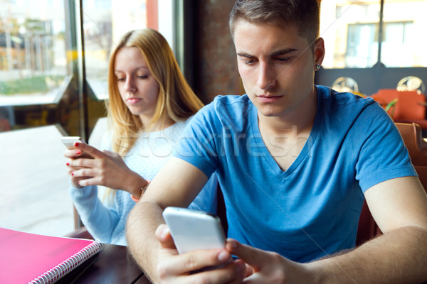 Group of friends using mobile phone in cafe. Stock photo © nenetus