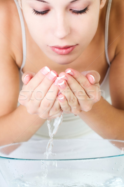Stock photo: Woman washing her face in the morning