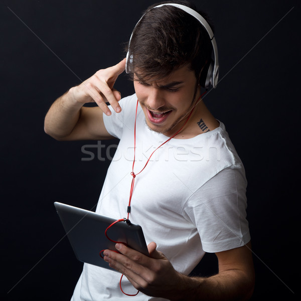 Jovem belo homem ouvir música isolado preto Foto stock © nenetus