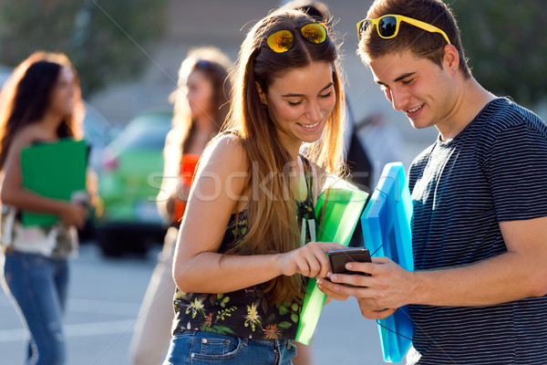 A group of students having fun with smartphones after class. Stock photo © nenetus