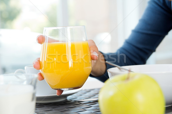 Woman's hand grabbing a glass of orange juice at breakfast Stock photo © nenetus