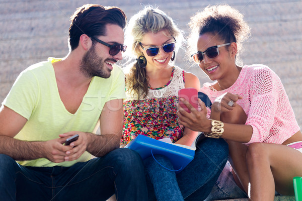 Group of university students using mobile phone in the street. Stock photo © nenetus