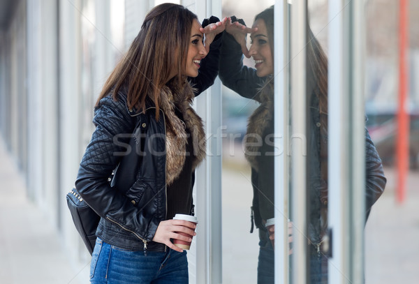 Young beautiful woman looking at the shop window. Stock photo © nenetus