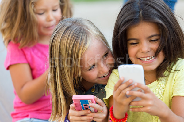 Group of childrens chatting with smart phones in the park. Stock photo © nenetus