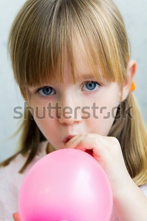 Cute little  girl inflating a pink balloon in the kitchen Stock photo © nenetus