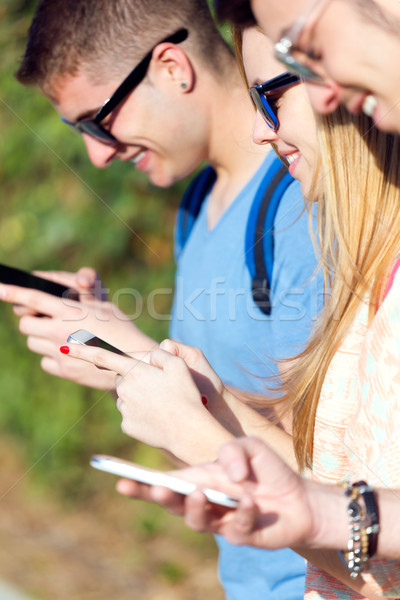 A group of students having fun with smartphones after class. Stock photo © nenetus