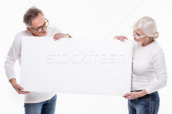 Senior beautiful couple with empty white board. Stock photo © NeonShot