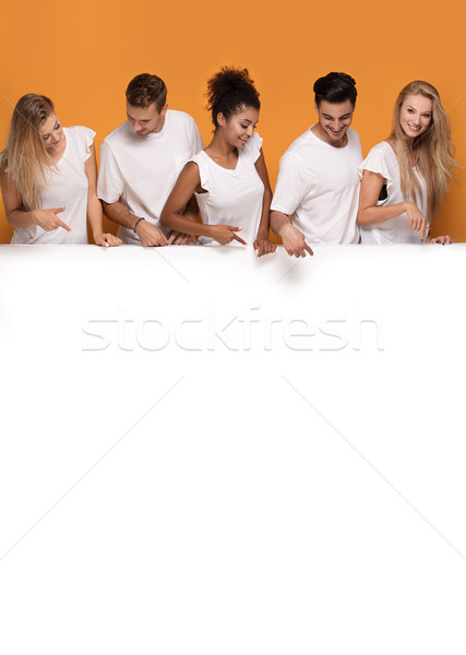 Pięć osób stwarzające biały pusty pokładzie grupy Zdjęcia stock © NeonShot