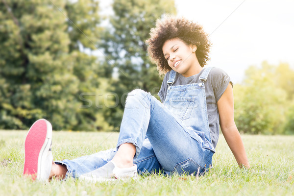 Stock photo: Young african girl relaxing in park.