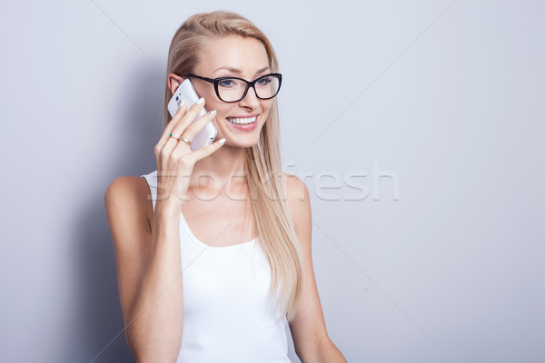 Young blonde woman talking by mobile phone. Stock photo © NeonShot