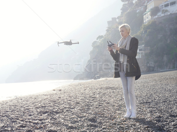 Young girl flying drone over italian coast. Stock photo © NeonShot