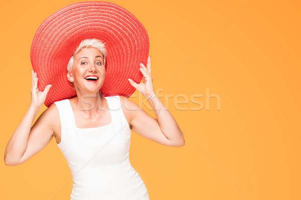 Mijloc varsta femeie zambitoare roşu vară pălărie Imagine de stoc © NeonShot