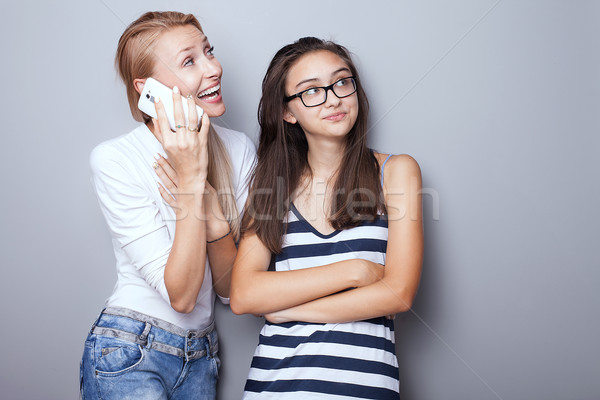 Foto stock: Dos · hermanas · posando · teléfono · móvil · hermosa · junto