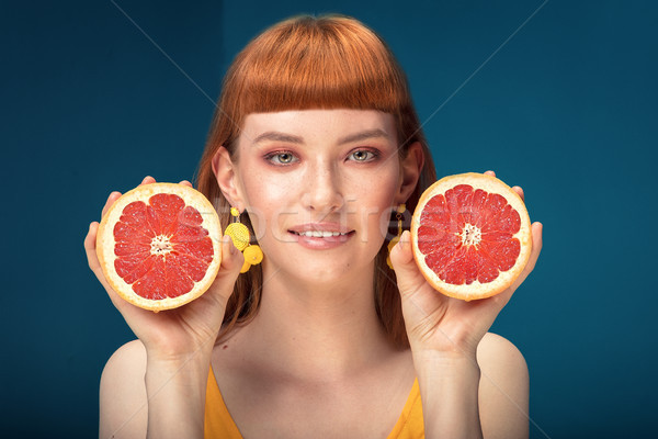 Girl with grapefruit on blue background. Stock photo © NeonShot
