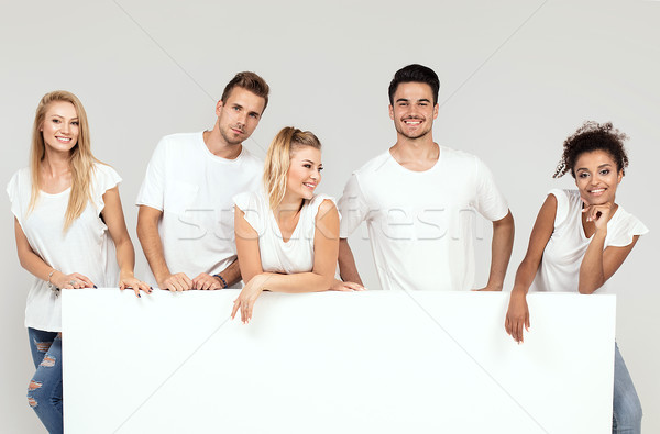 Group of smiling people with empty white board. Stock photo © NeonShot