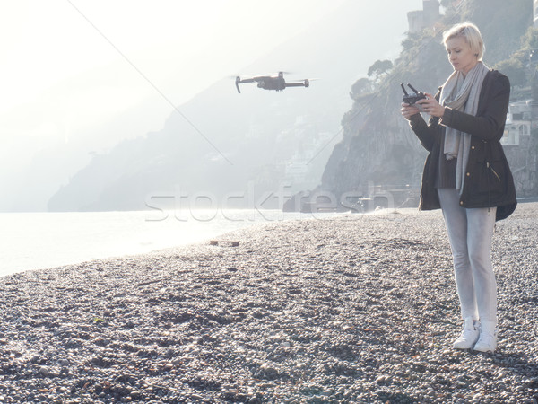 Young girl flying drone over italian coast. Stock photo © NeonShot