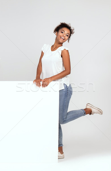 Smiling african american woman with empty white board. Stock photo © NeonShot
