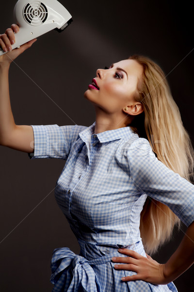 Blonde girl using hair dryer. Stock photo © NeonShot