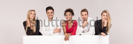 Stock photo: Group of elegant young people posing with sale letters.