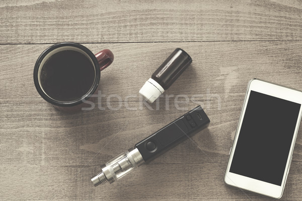 Vaping set,  smartphone and coffee on the wood table. Stock photo © nessokv