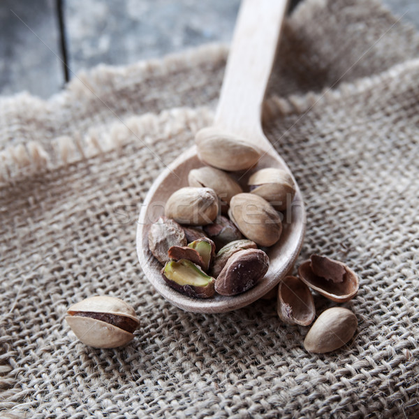 Dried Pistachio Nuts In A Wooden spoon Stock photo © nessokv