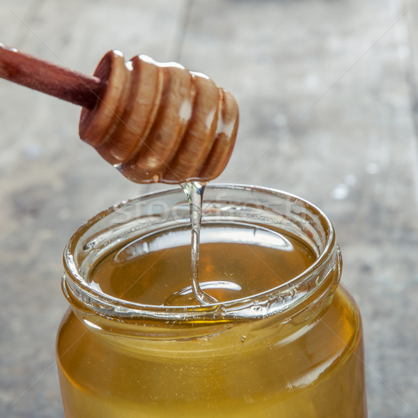 Glass honey jar with dipper Stock photo © nessokv
