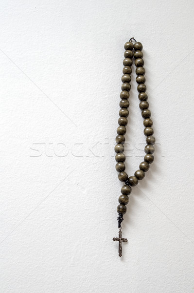 rosary beads hanging against white wall Stock photo © nessokv