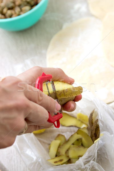  hands peeling potato with peeler Stock photo © nessokv