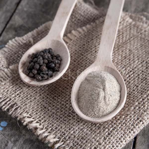 Black and white pepper on wooden background Stock photo © nessokv