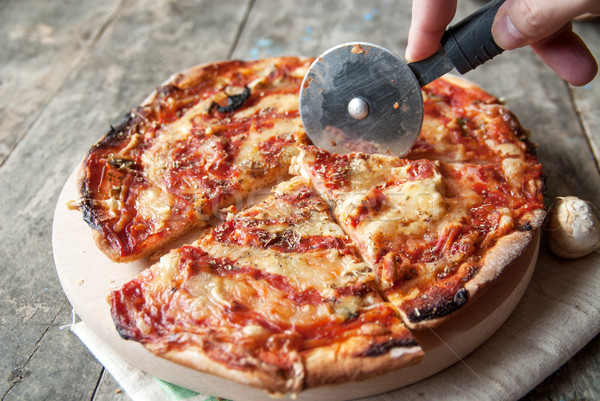 Cutting homemade pizza on old table Stock photo © nessokv