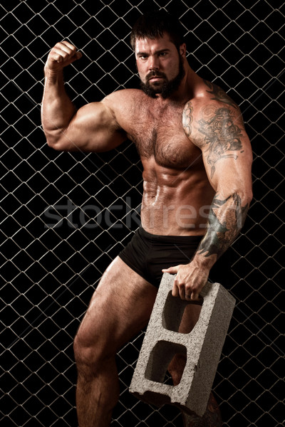 Bodybuilder posing in front of chain link. Stock photo © nickp37