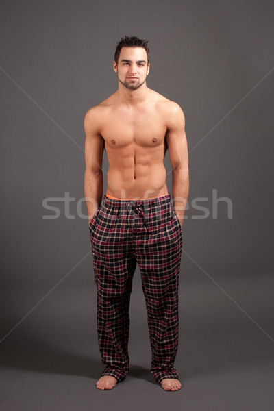 Attractive man in pajamas. Studio shot over grey. Stock photo © nickp37