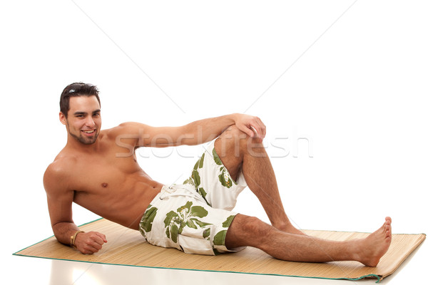 Stock photo: Attractive young man in boardshorts. Studio shot over white.