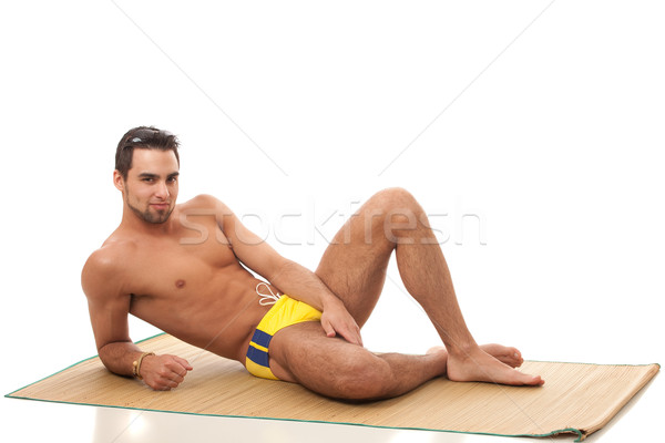 Attractive young man in swimsuit. Studio shot over white. Stock photo © nickp37
