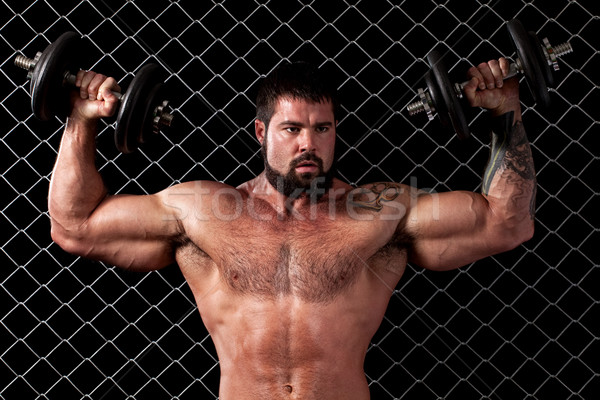 Bodybuilder posing in front of chain link. Stock photo © nickp37