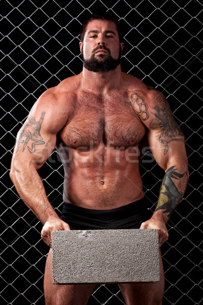 Bodybuilder posing in front of chain link. Stock photo © nickp37