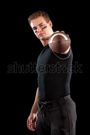 Stock photo: American football player. Studio shot over black.