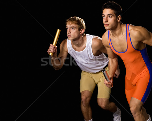 Relay racers in motion. Studio shot over black. Stock photo © nickp37