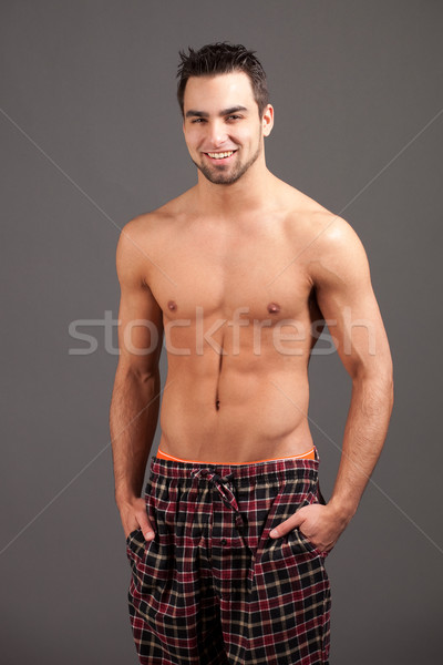 Attractive man in pajamas. Studio shot over grey. Stock photo © nickp37