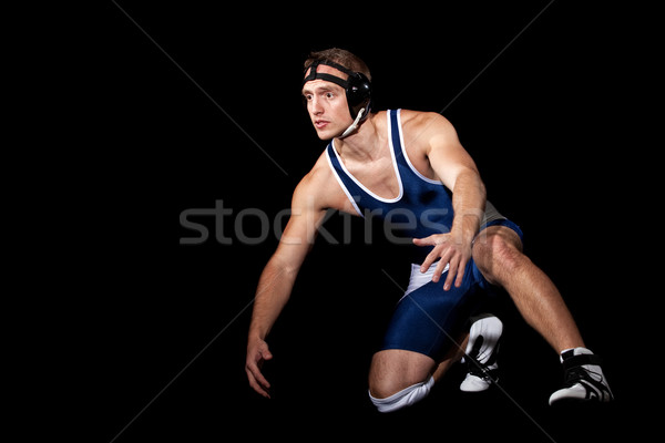 Stock photo: Wrestler in a blue singlet. Studio shot over black.