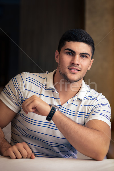 Young Man Sitting in a Restaurant Stock photo © NicoletaIonescu