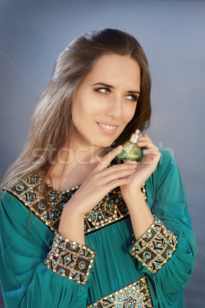 Young Woman Holding Perfume Bottle in Seaside Landscape Stock photo © NicoletaIonescu