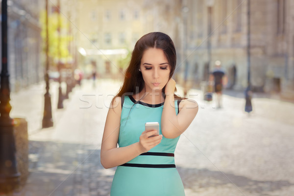Curious Girl Looking at Her Phone Stock photo © NicoletaIonescu