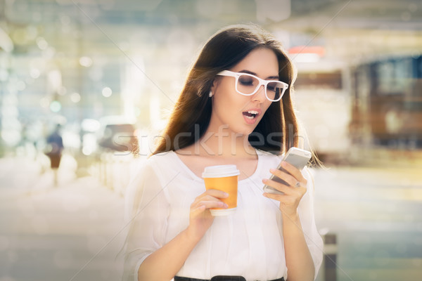 Amazed Young Woman Looking at Her Phone Stock photo © NicoletaIonescu