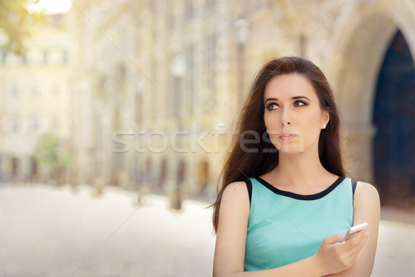 Undecided Woman with Smartphone out in the City Stock photo © NicoletaIonescu