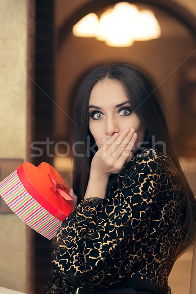 Surprised Beautiful Woman Holding Heart Shape Gift Stock photo © NicoletaIonescu