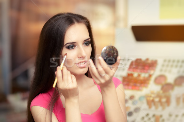 Beautiful Woman with Make-up Brush Looking in a Mirror Stock photo © NicoletaIonescu
